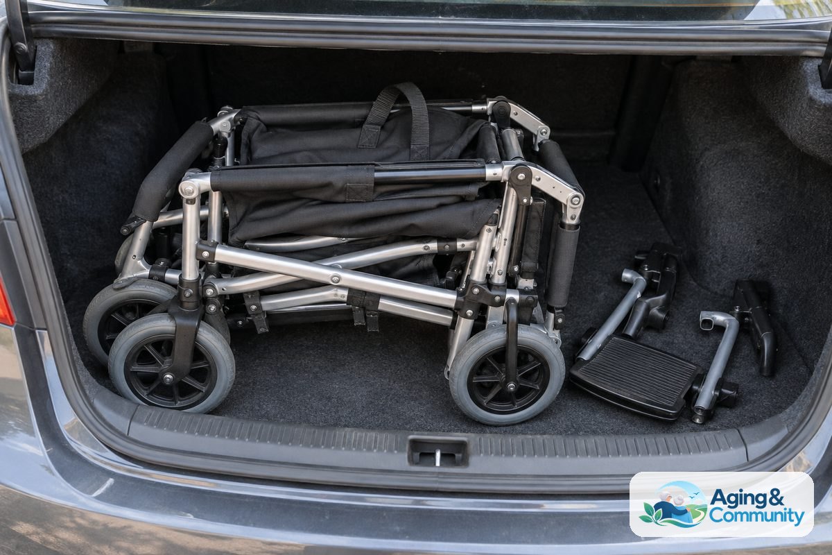 How to Choose a Transport Chair: A Clear Buying Guide 4 A folded aluminum transport chair rests inside an open car trunk with its backrest folded down and fabric carry loops visible.